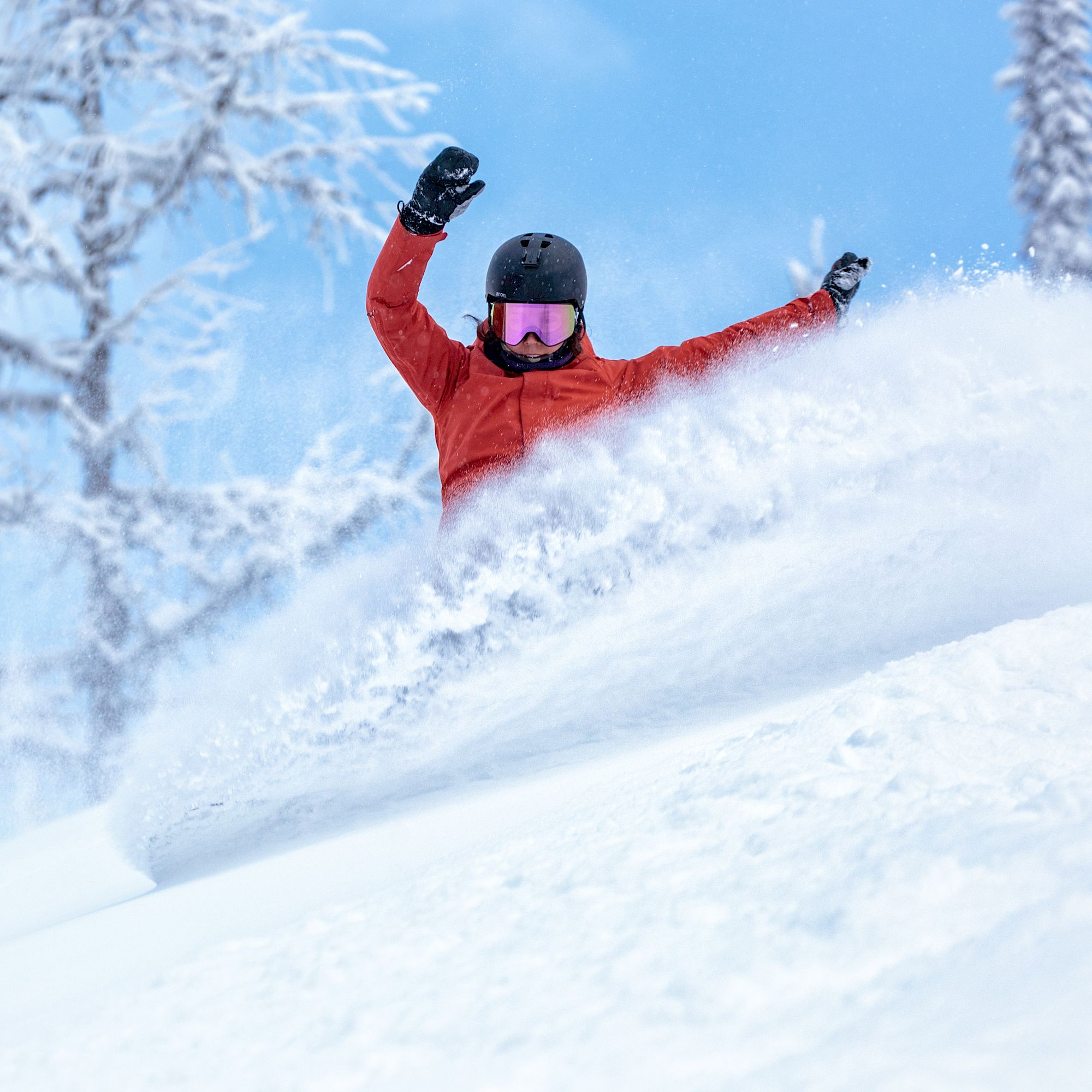 Female Snowboarder Slashing Powder In Red Jacket On The Trash Chutes Run.