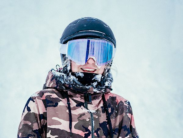 Estelle Pensiero In A Pink Camo Jacket Holding a Snowboard.